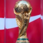 FIFA World Cup trophy displayed on a pedestal at the launch event in Vancouver with crowd gathered around