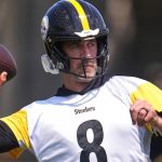 Aaron Rodgers in Steelers uniform winding up to throw a pass during practice session on the field