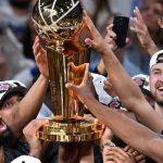 New York Knicks player dribbles basketball between two San Antonio Spurs defenders during NBA final game